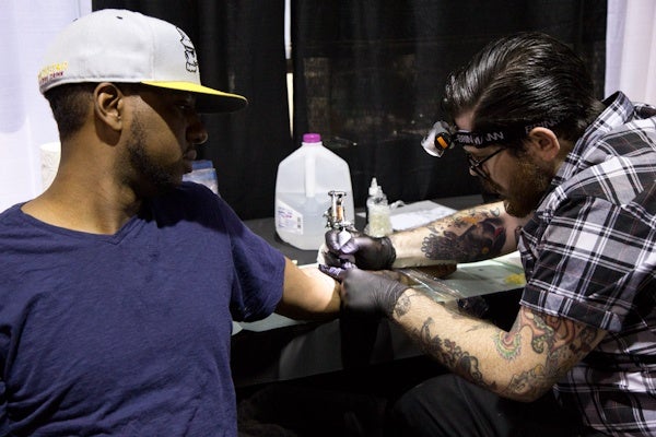 Steve Powell is getting his 9th tattoo, a sad clown by artist Talley.  (Kimberly Paynter/WHYY)