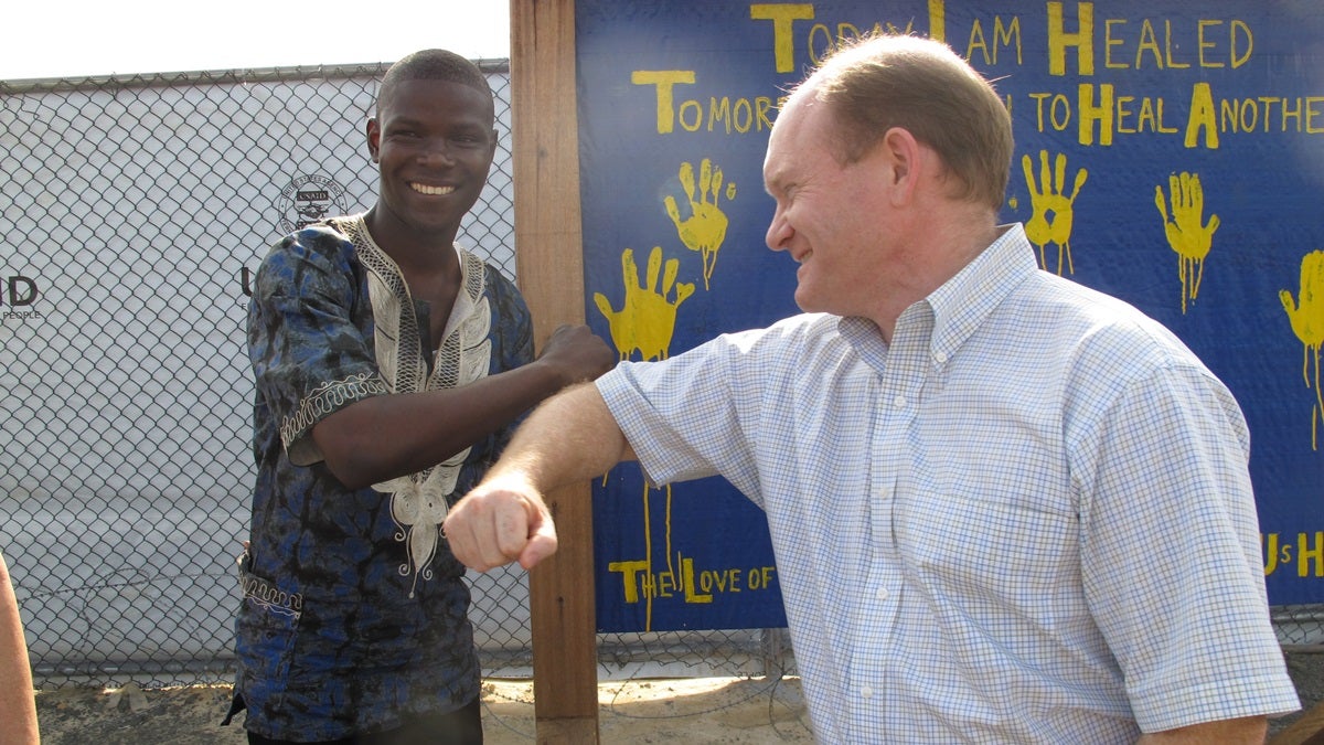  Sen. Chris Coons greets a Liberian Ebola survivor with an 