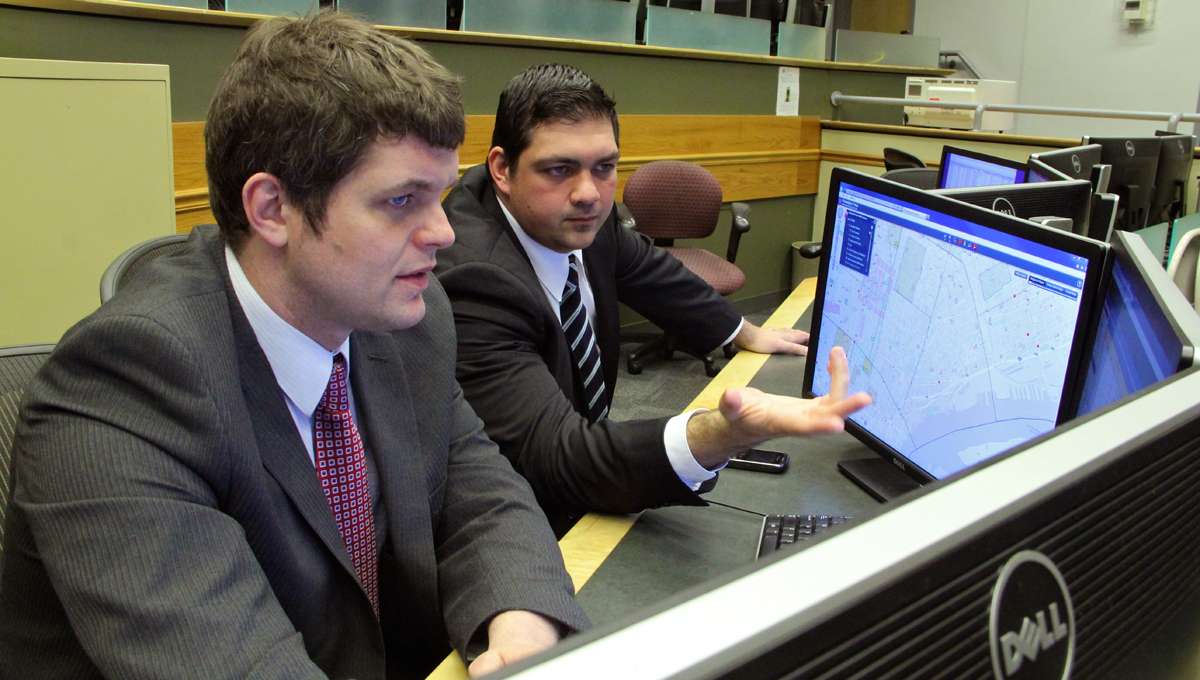 Philadelphia police data experts Kevin Thomas (left) and Anthony D'Abruzzo review data at the Crime Analysis Lab at police headquarters.