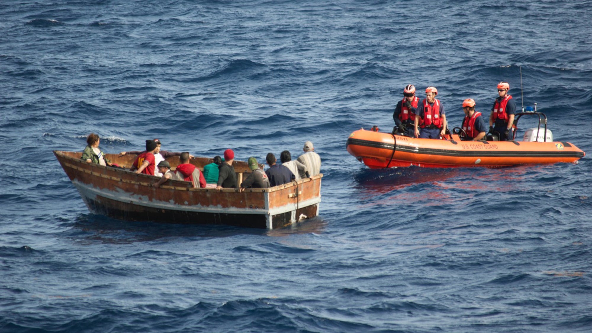  In 2014, crew members of the  U.S. Coast Guard Cutter Knight Island approach a boat with 12 Cuban migrants southwest of Key West, Florida.  (AP Photo/U.S. Coast Guard) 
