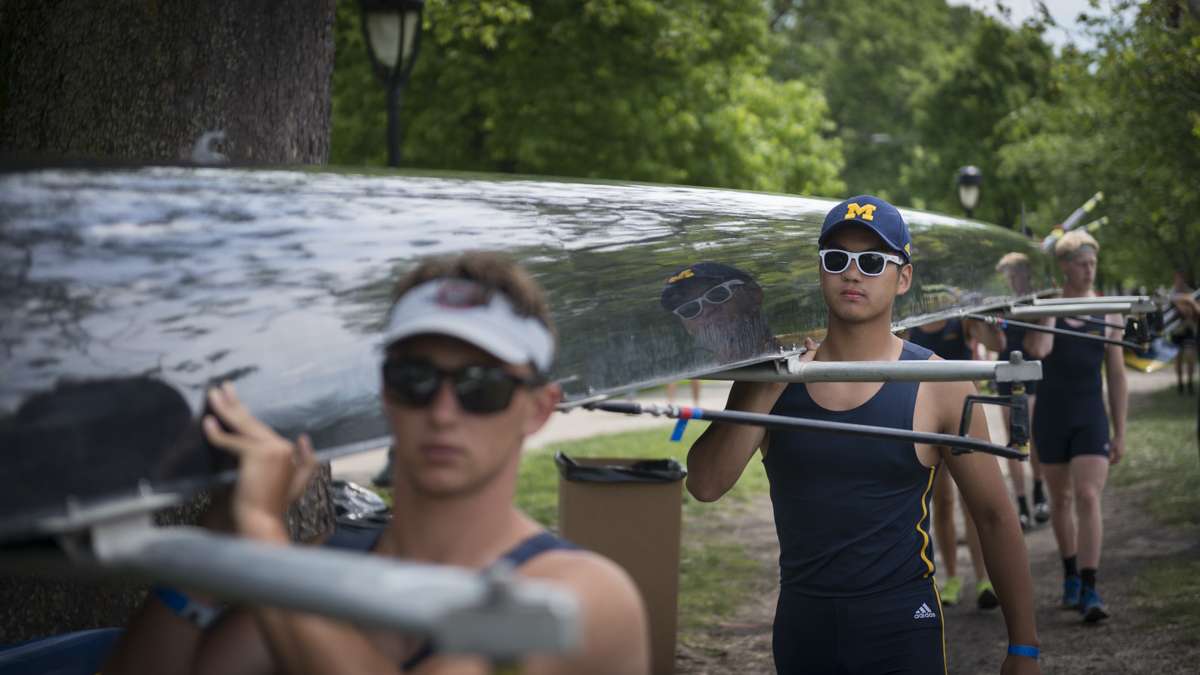 Athletes carry their boat toward the Schuylkill River for the competition.