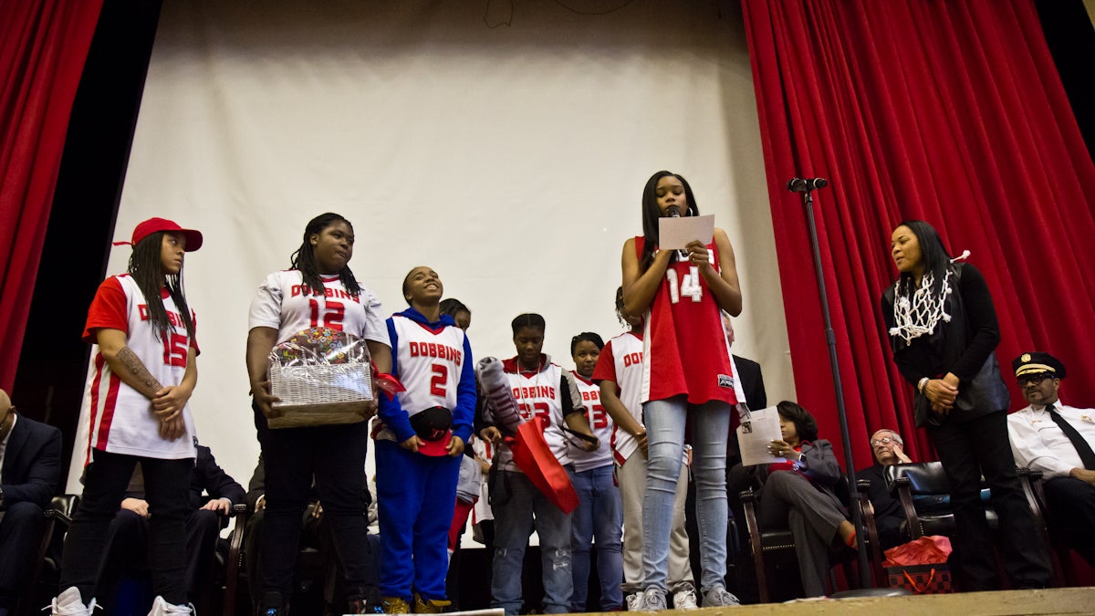 The Dobbins girls basketball team presents coach Dawn Staley with Dobbins gear. (Kimberly Paynter/WHYY)