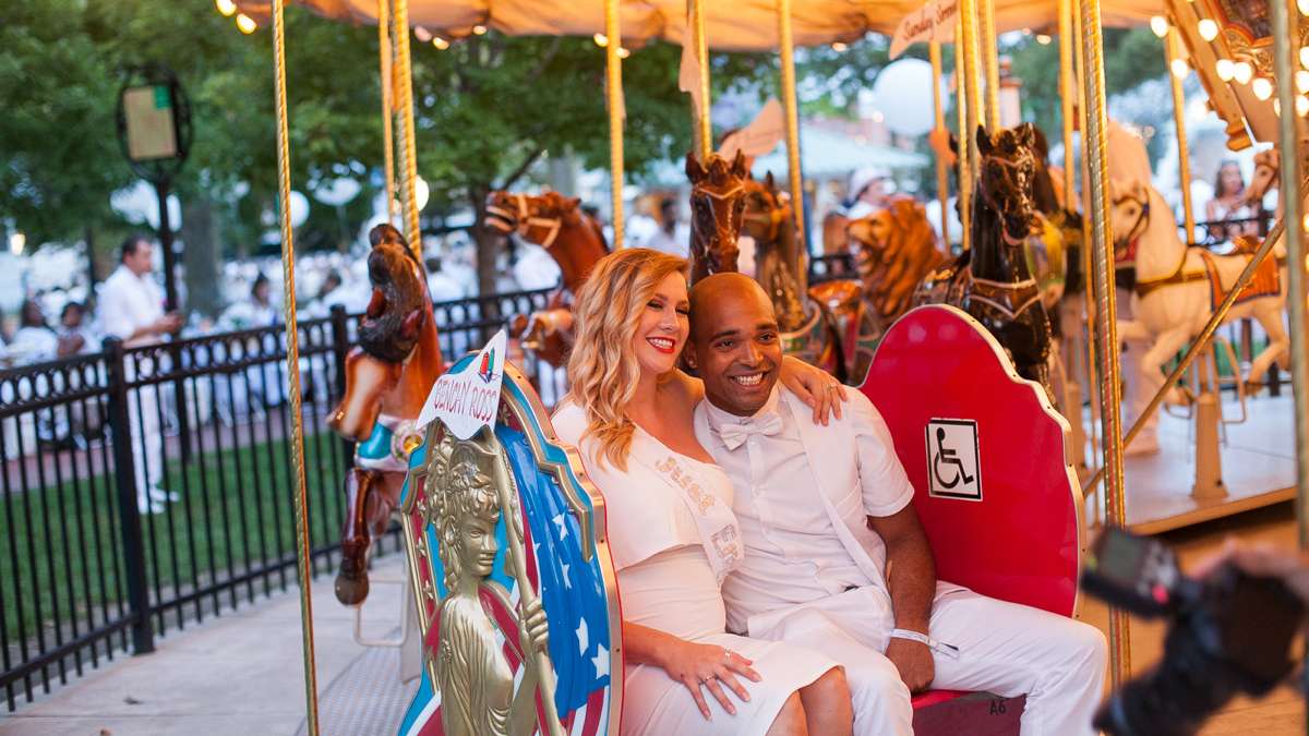 Diners ride the carousel in Franklin Square Thursday evening during the sixth annual Dîner en Blanc. (Brad Larrison for NewsWorks)