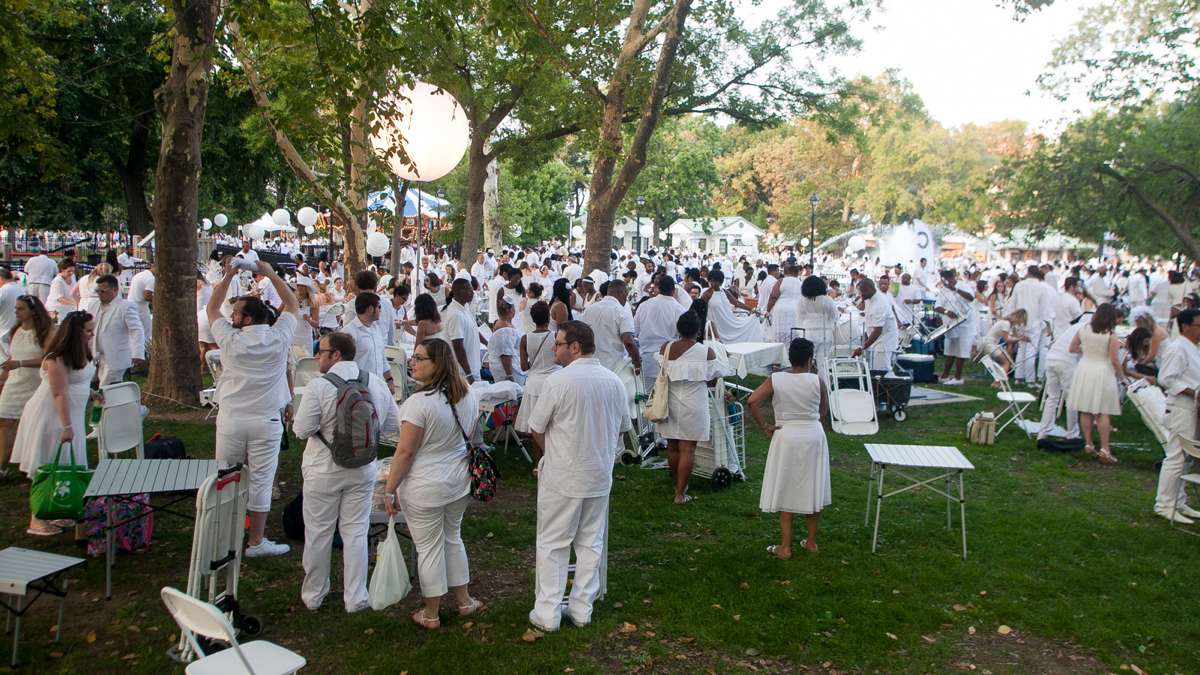 Franklin Square fills as participants in the annual Dîner en Blanc set up their tables on the grass. (Brad Larrison for NewsWorks)