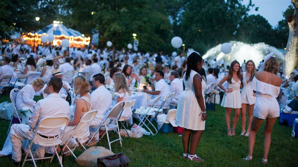 As evening deepens and lights come up, participants in the sixth annual Dîner en Blanc take time for photos. (Brad Larrison for NewsWorks)