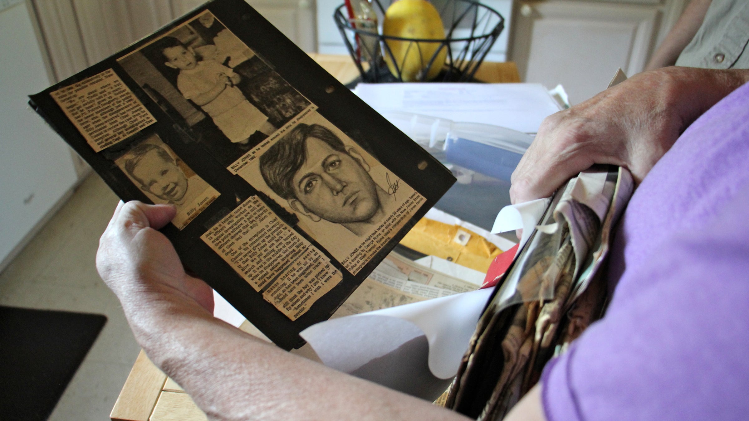  Jill Jones Neville looks through newspaper clippings about the disappearance of her brother, Billy Jones, more than 50 years ago, when he was three. (Emma Lee/WHYY) 