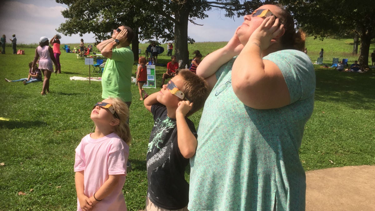  Families wore eclipse glasses to look up at the natural phenomenon.(Zoë Read/WHYY) 