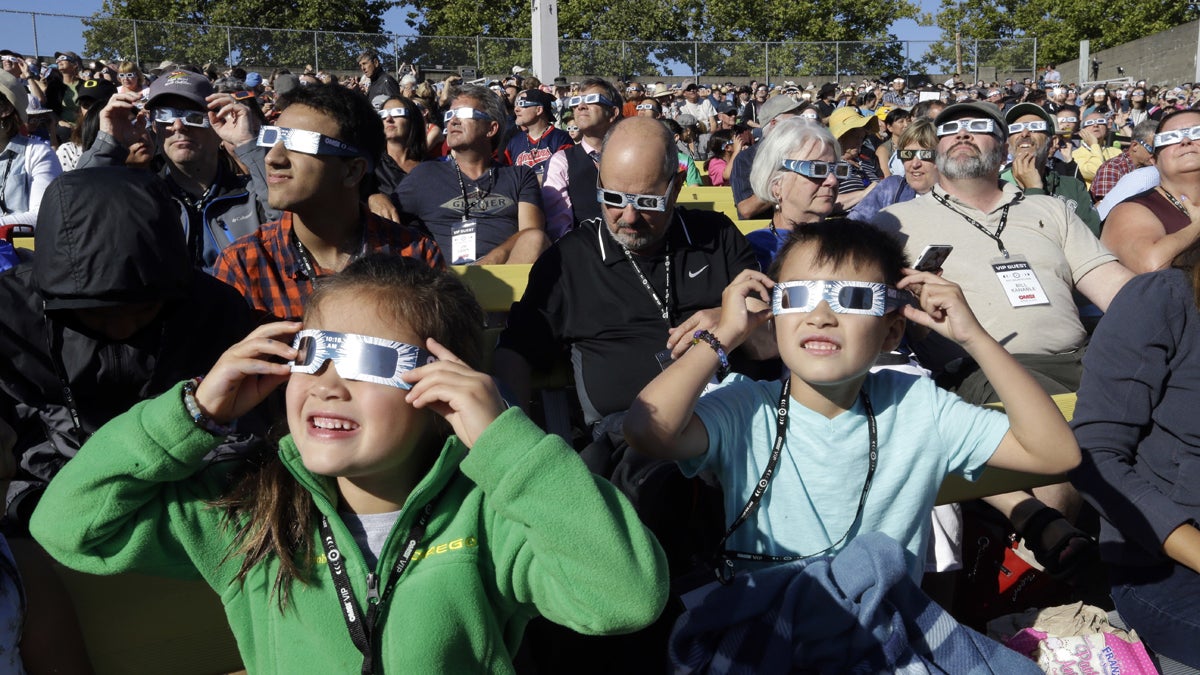  A crowd wears protective glasses as they watch the beginning of the solar eclipse from Salem, Ore., Monday, Aug. 21, 2017. (AP Photo/Don Ryan) 