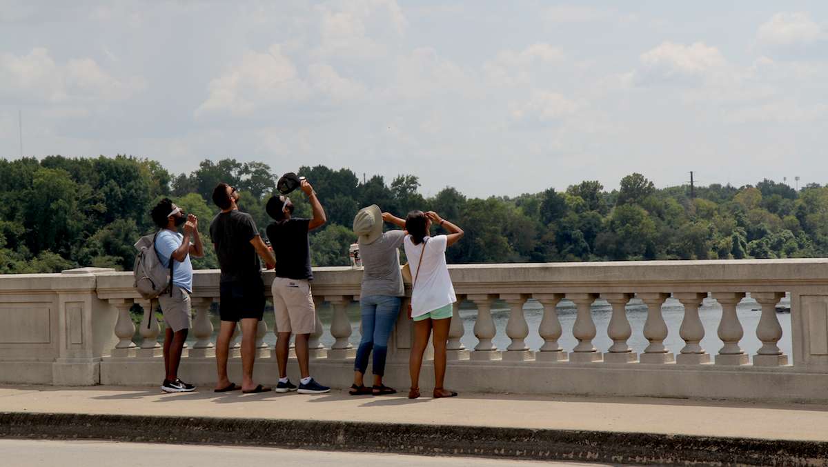 People gather on the Gervais Bridge in Columbia, South Carolina, to view the total solar eclipse. (Kimberly Paynter/WHYY)