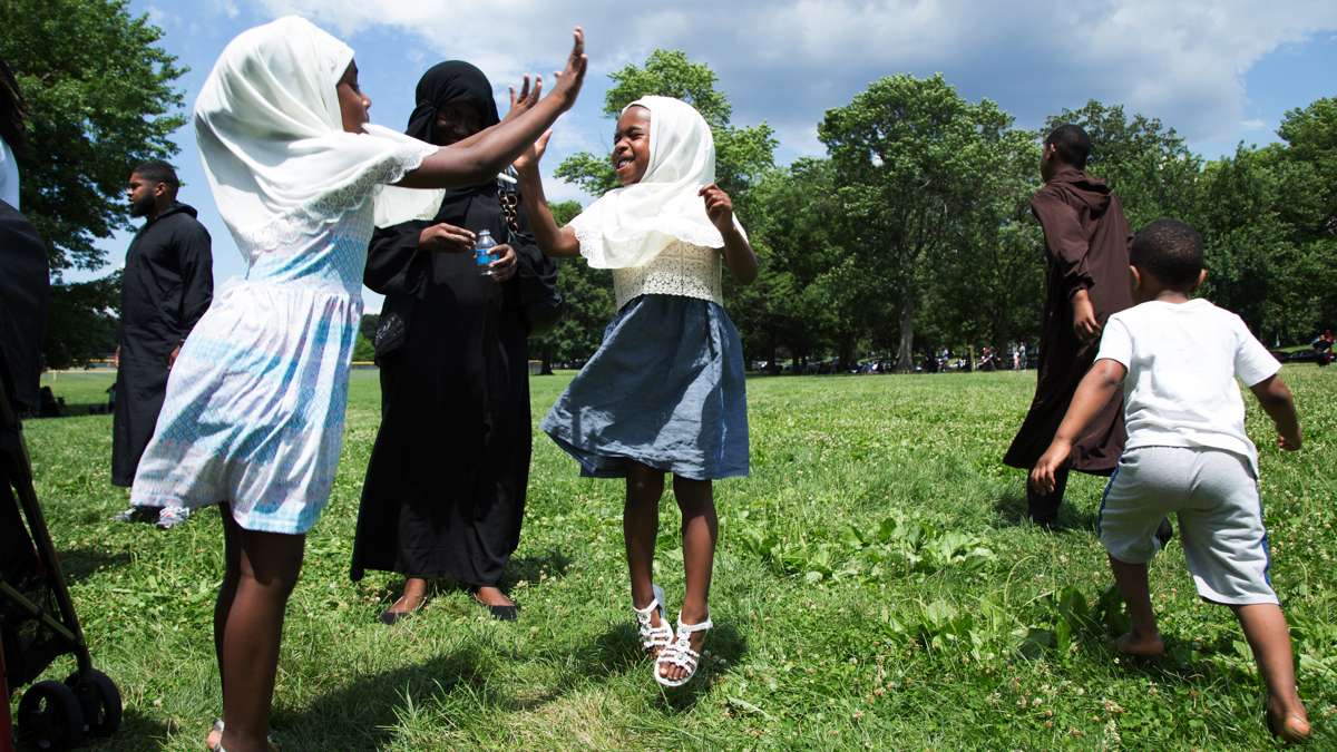 Two sisters jump and play while at Eid al-Fitr festivities in FDR Park