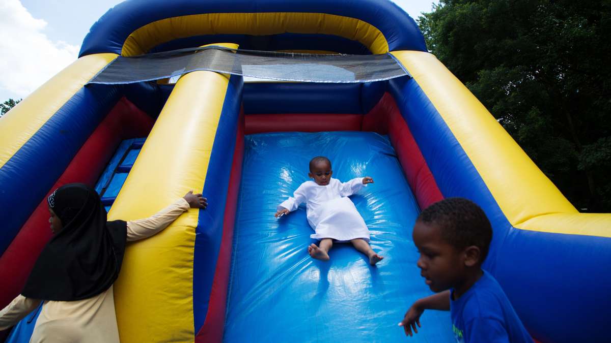 A young boy slides down an inflatable slide