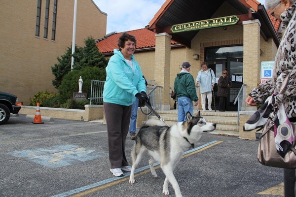 <p>Kathleen Wheatcraft waits with her dog outside of St. Francis Cabrini Church, a busy polling place in Ocean City. (Emma Lee/for NewsWorks)</p>
