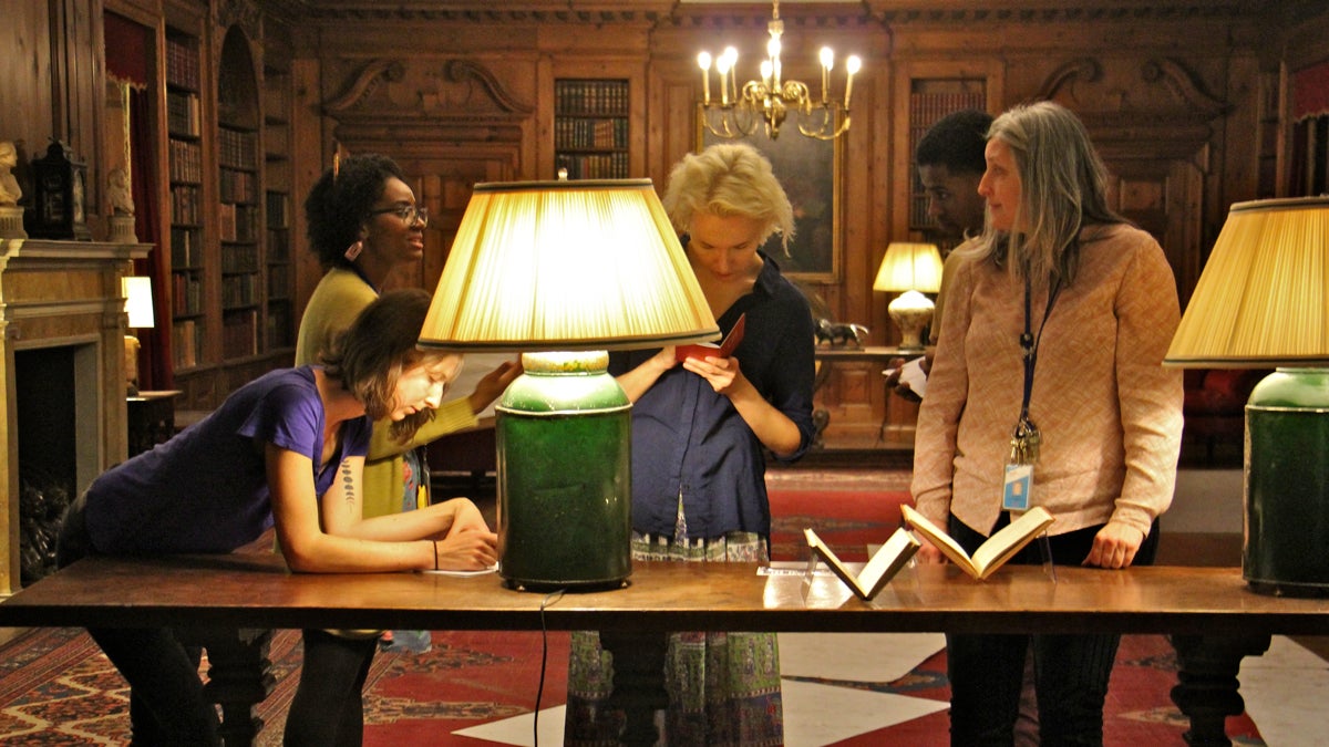  Visitors to the Free Library of Philadelphia look for clues in rare books in the Elkins Room as part of an immersive theater experience celebrating the detective novel. (Emma Lee/WHYY) 