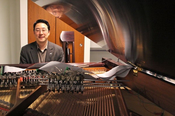 <p><p>Dr. Youngmoo Kim, director of Drexel's ExCITe Center, sits at his magnetic resonator piano. Electromagnets, rather than hammers, can cause the piano's strings to vibrate. (Emma Lee/for NewsWorks)</p></p>
