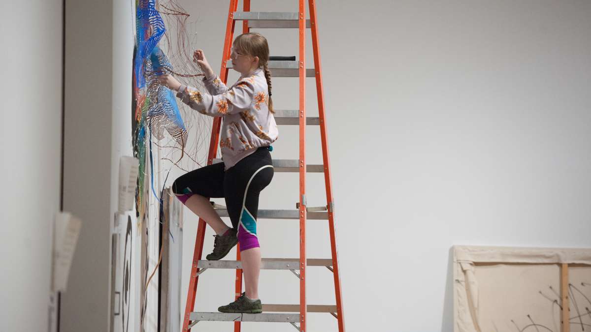 Justine Ditto works on a wall installation.
