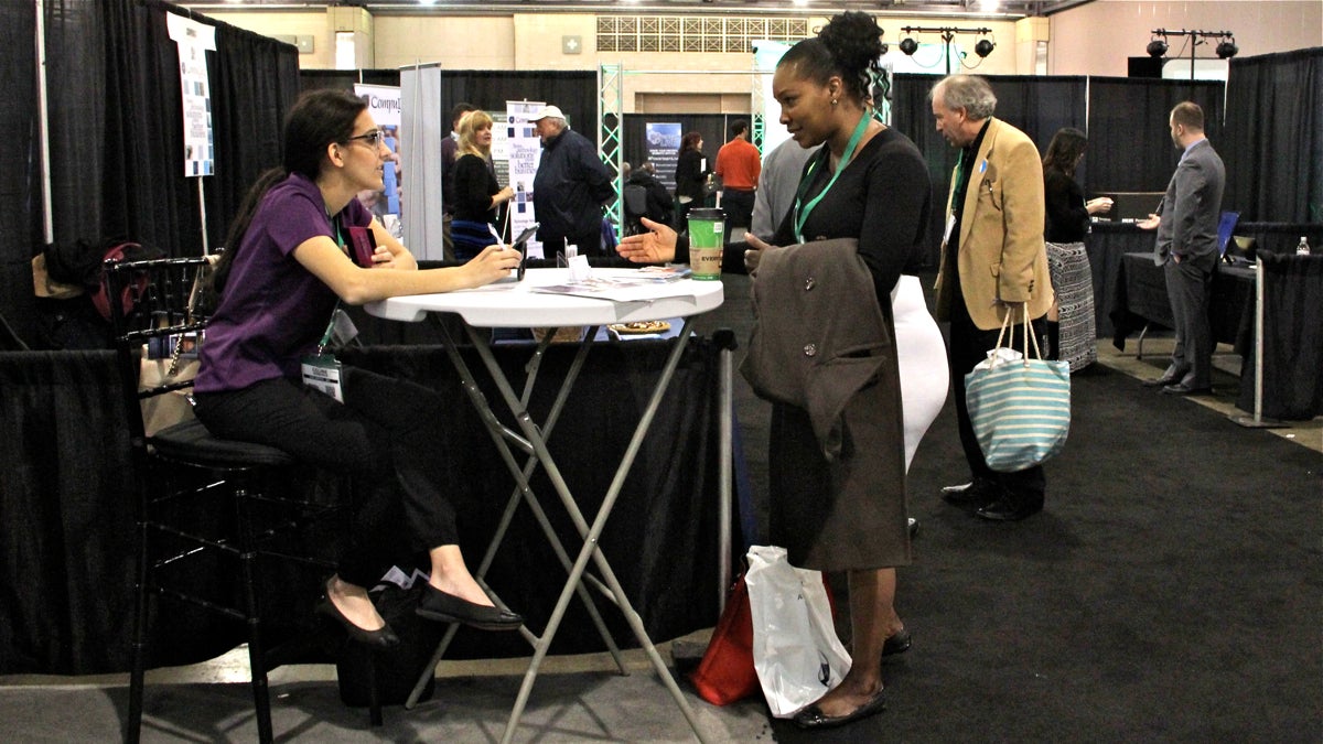 At the Small Business Expo esthetician Jae Barnes talks with Can Capital's Celine Romanus about building credit for her Fishtown business. (Emma Lee/WHYY)
