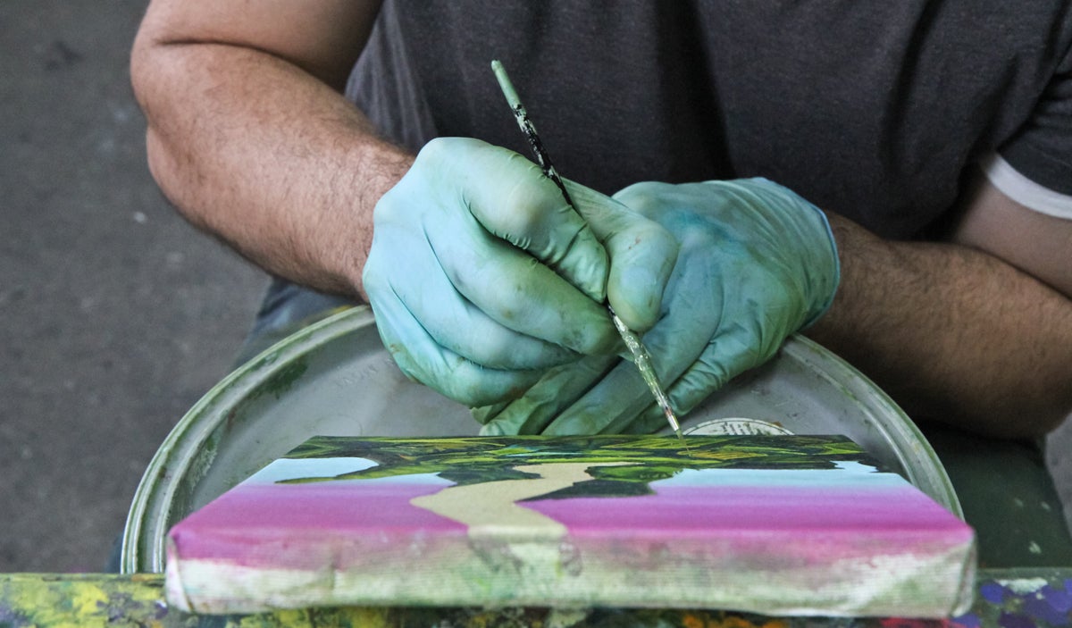  Fabian Lopez works on an abstract landscape painting in his Philadelphia studio.  (Kimberly Paynter/WHYY)  