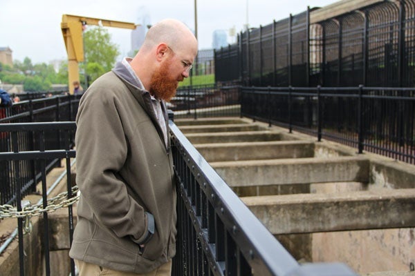 Fisheries biologist Joe Perillo looks for signs of migrating fish in the Fairmount fish ladder. (Emma Lee/for NewsWorks)