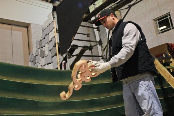 <p>Ryan Eells, mummer for 15 years, of the Jokers Brigade spray paints a prop for the 2013 show. (Kimberly Paynter/WHYY)</p>
