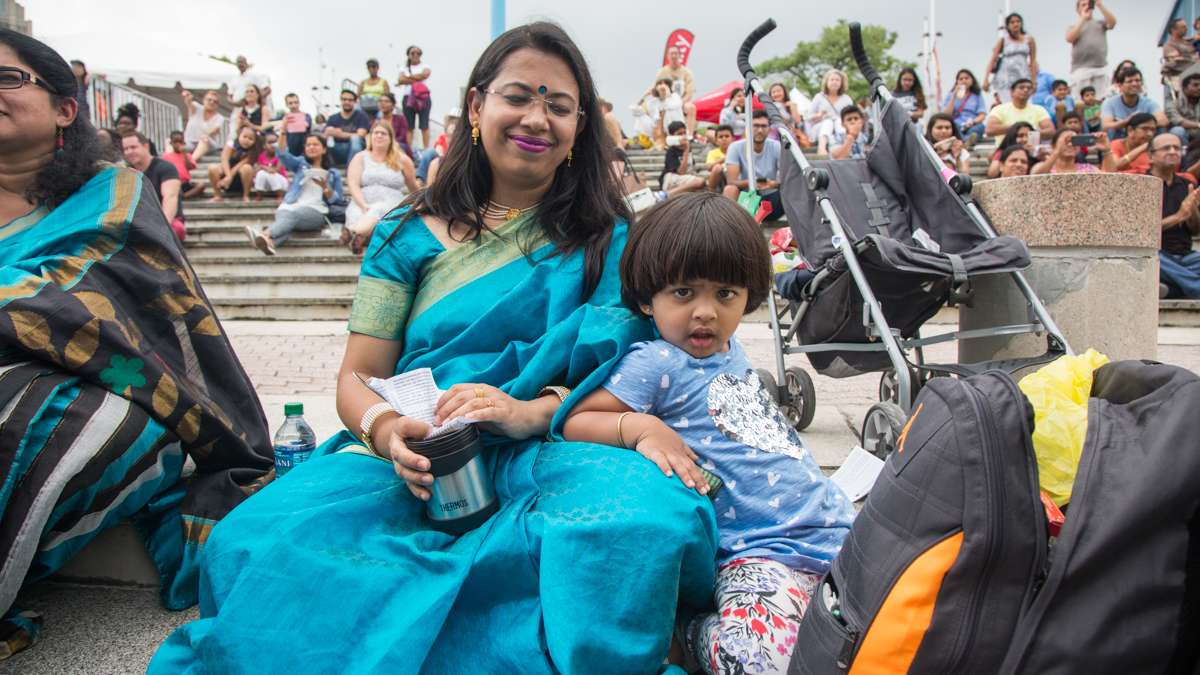 Malini Mazumdar and 2-year-old Ashmi take in the colorful Bollywood dancing at the Festival of India at Penn’s Landing. (Emily Cohen for NewsWorks)