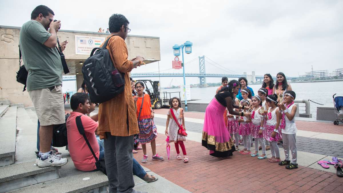 A dance group poses for a photo with the trophy they recieved for dancing in the festival. (Emily Cohen for NewsWorks)