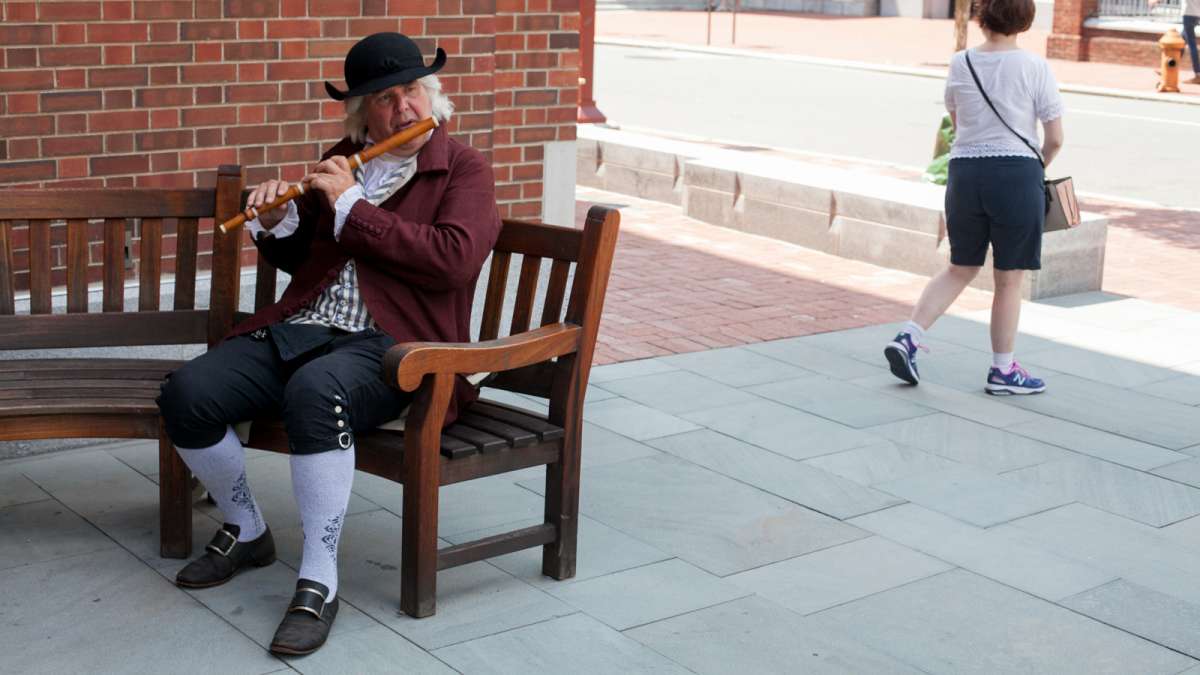 A Revolutionary War Renactor sits outside of the Museum of the American Revolution Saturday. (Brad Larrison for NewsWorks)