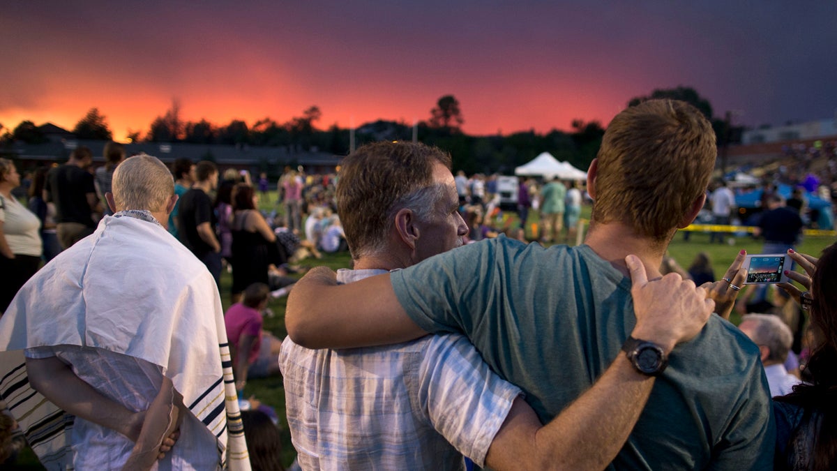  The sun sets as mourners gather for a candlelight vigil in Prescott, Ariz. Tuesday, July 2, 2013 to honor the 19 Granite Mountain Hotshot firefighters who were killed by an out-of-control blaze near Yarnell, Ariz. on Sunday. (AP Photo/Julie Jacobson) 