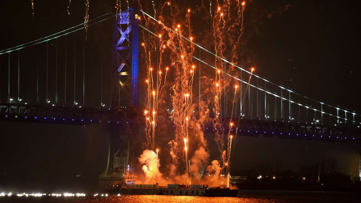 The New Year's fireworks shoot off from a barge just south of the Benjamin Franklin Bridge.