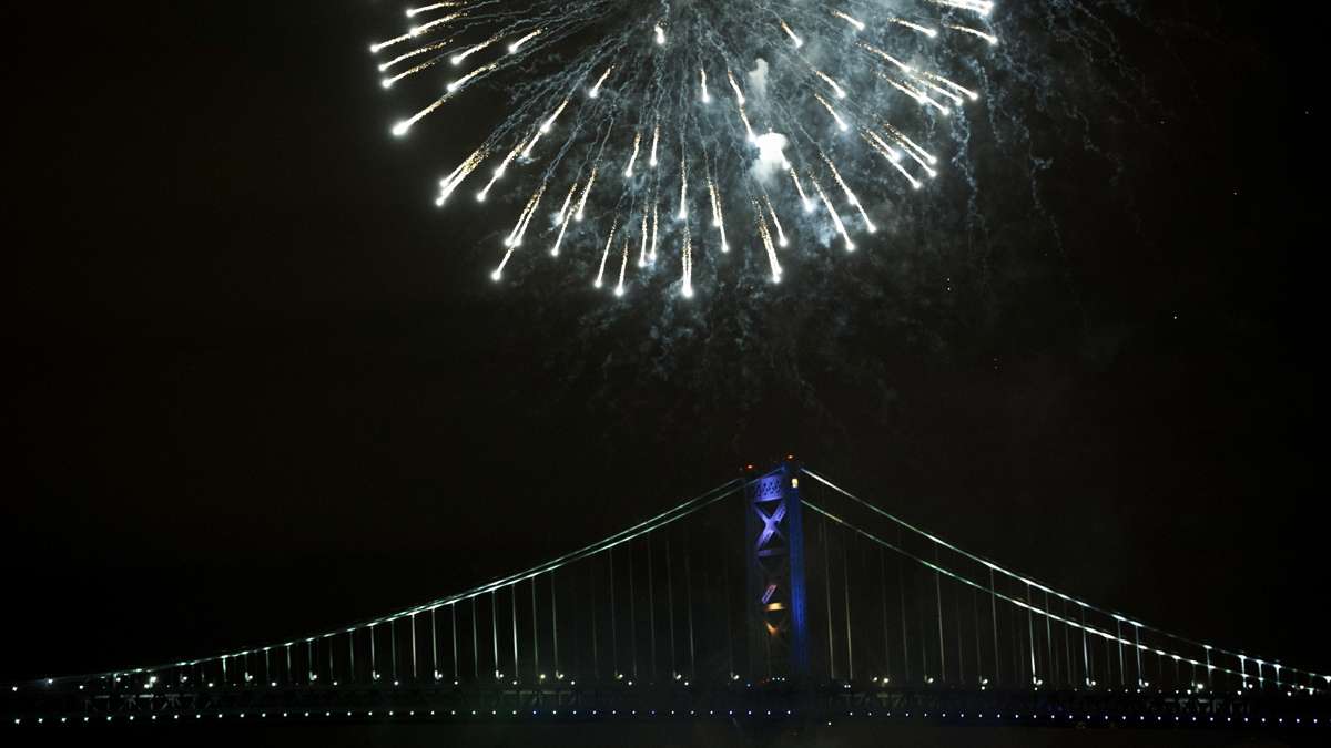 Midnight fireworks eplode over the Ben Franklin Bridge as seen from Penn's Landing.