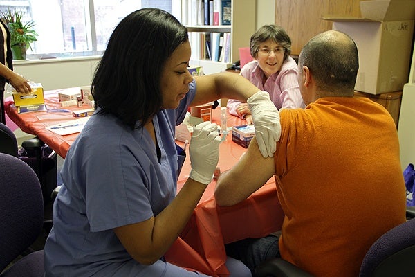 <p>Thomas Jefferson nurse Clarissa Knight injects Teo Reyes with a flu shot. The Thomas Jefferson Hospital Center for Urban Health, working with the Restaurant Opportunities Center of Philadelphia, is providing free flu shots for restaurant workers. (Emma Lee/for NewsWorks)</p>
