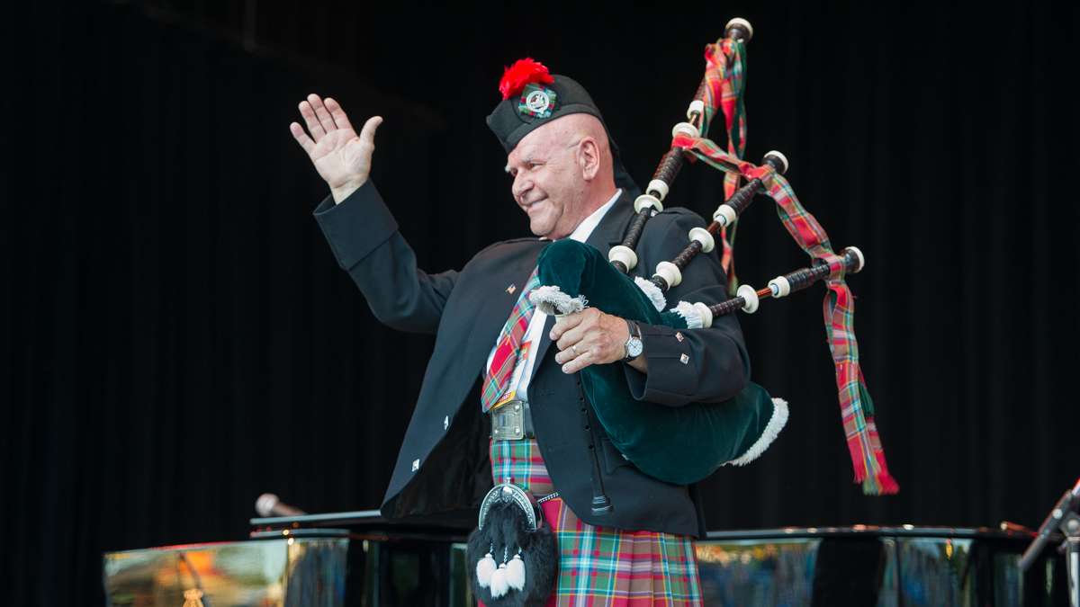 Bagpiper Dennis Hangey acknowledges the audience at the opening of the Saturday night concert. Hangey has been opening Folk Festival concerts for more than 35 years.
