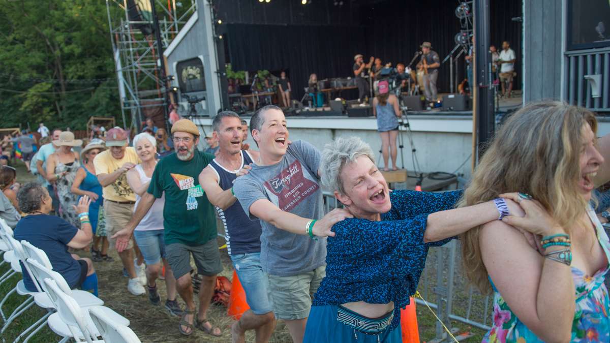 Audience members form a conga line as Baile An Salsa performs. (Jonathan Wilson for NewsWorks)