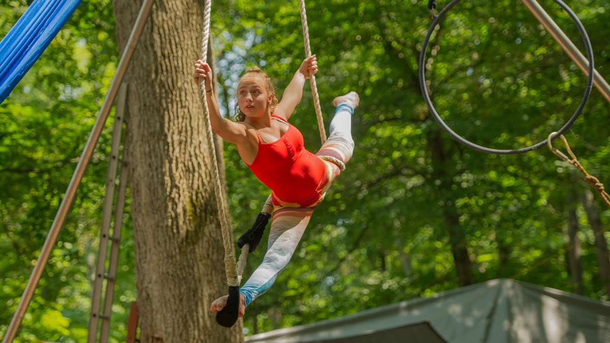 Cassie Haberle, 13, performs on the trapeze in Dulcimer Grove. Haberle is a performer with the Give and Take Little Circus. (Jonathan Wilson for NewsWorks)