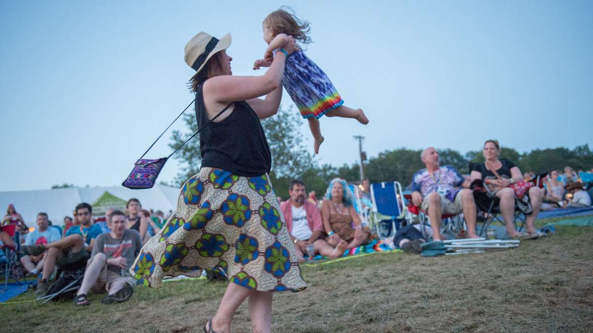Azalea Bernstein swings her daughter Tegan, who was attending her first folk festival. (Jonathan Wilson for Newsworks)