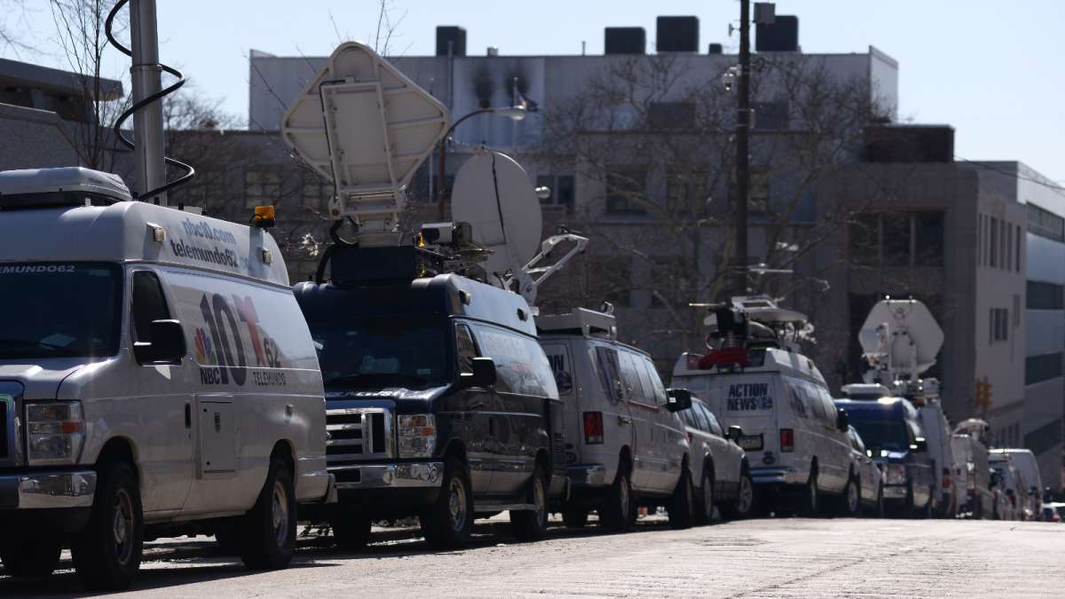 A large number of news vans line both sides of Swede Street, on the west side of the courthouse.