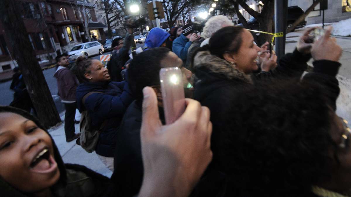 A waiting crowd uses cell phone cameras to capture images of Cosby as he walks from the courthouse towards his car.