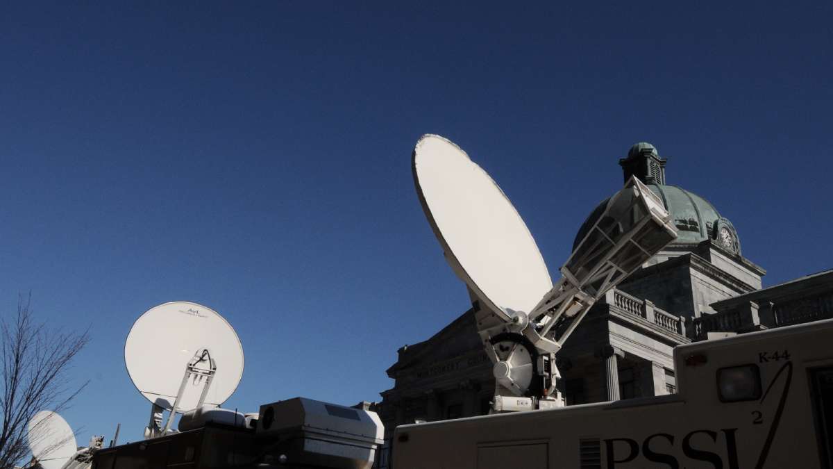 Satellite vans responsible for transmitting live feeds have their dishes pointed skywards.
