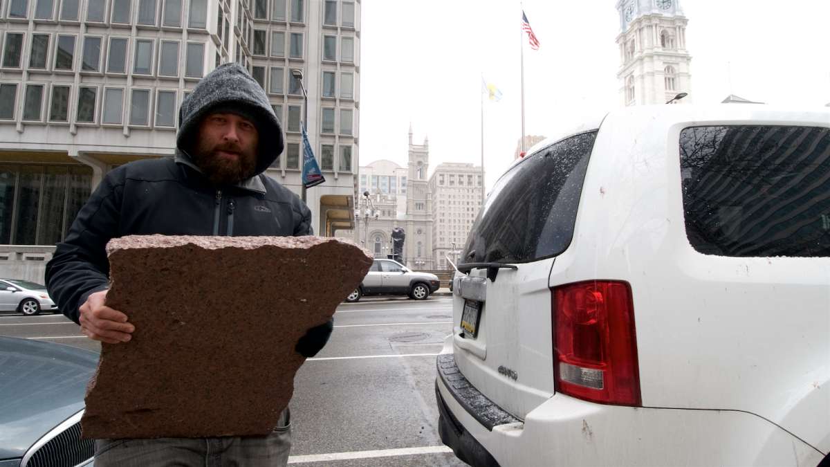 Ryan Gee hauls a sizable piece of red granite to the trunk of his car. He wants to bring it home as a keepsake.