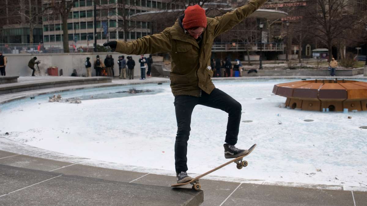 Scott Mantua of Jim Thorpe, Pennsylvania performs tricks on a ledge around the fountain base as he tries to keep on riding throughout the snow.