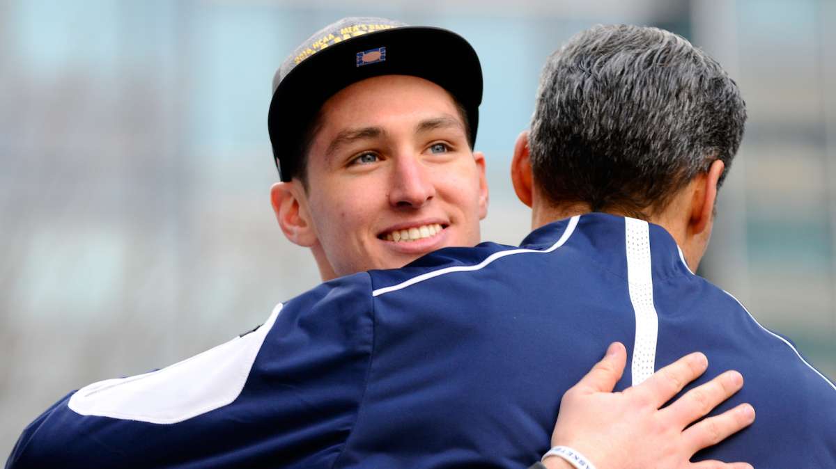 Wildcats' Ryan Arcidiacono embraces Head Coach Jay Wright as he looks at the crowds gathered for the ceremony.