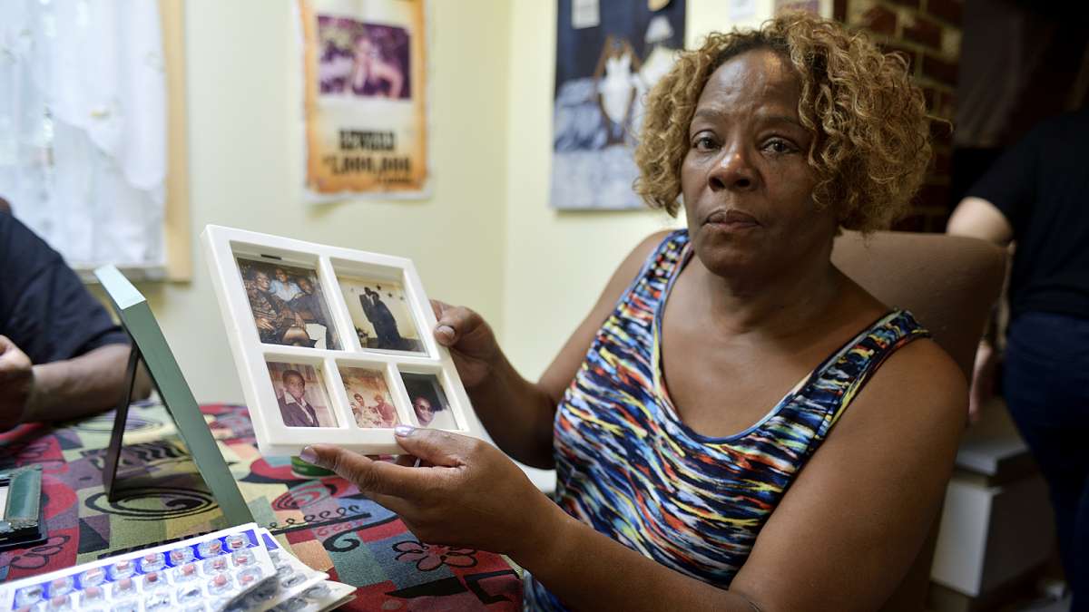 Michelle Witherspoon holds up a picture frame with photos of Kenyada Jones.