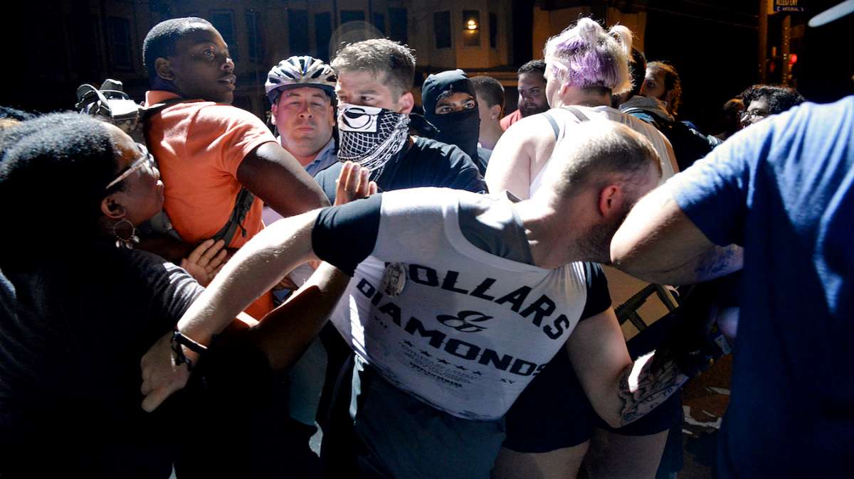 A police officer is seen trying to arrest an unidentified British tourist. Megan Malachi, spokesperson for the Philly Coalition for REAL Justice, is seen on the far left engaging in the action.