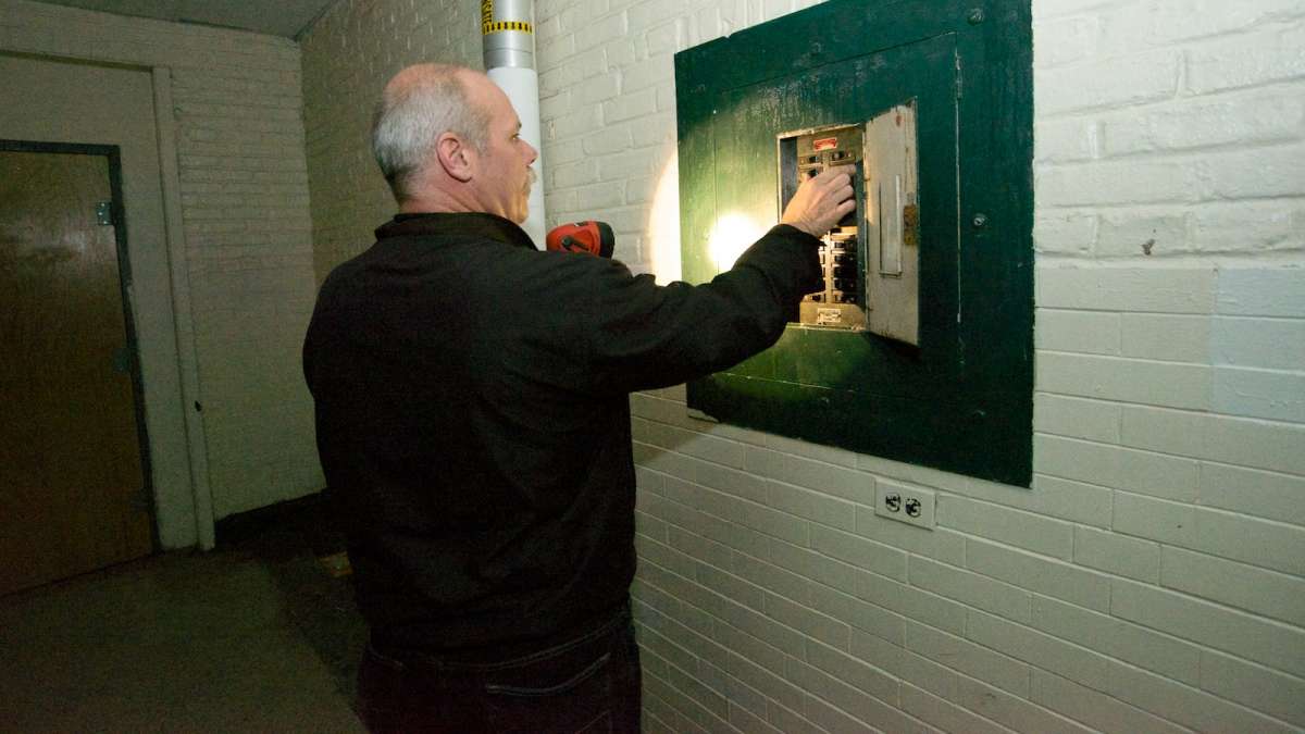 Rich Toohey, SPD assistant NW facilities manager, turns the lights on inside the shuttered Germantown High School building. (Bas Slabbers/for NewsWorks)