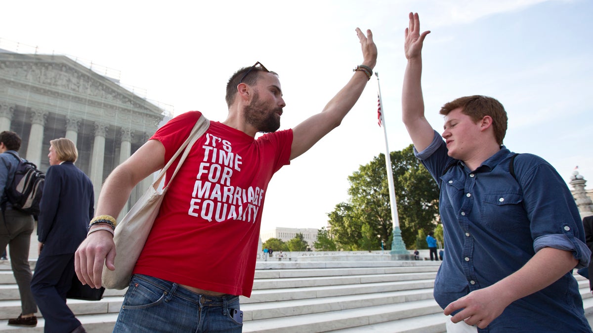  Gay rights activist Bryce Romero, of the Human Rights Campaign, offers an enthusiastic high-five on Wednesday to visitors getting in line to enter the Supreme Court before justices handed down major rulings on two gay marriage cases that impact same-sex couples across the country. (AP Photo/J. Scott Applewhite, file) 