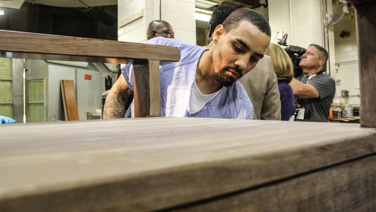 Inmate Evan Davis sands the chair that Philadelphia inmates are making for Pope Francis. (Kimberly Paynter/WHYY)