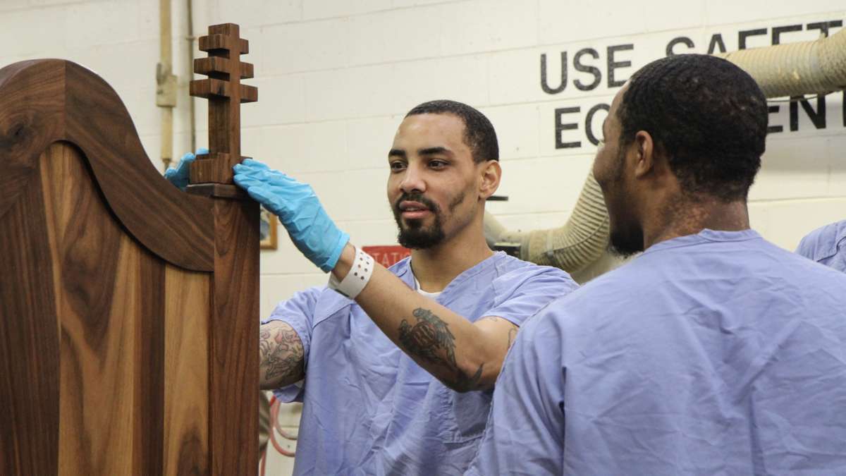 Inmate Evan Davis installs one of the chair's crosses. (Kimberly Paynter/WHYY)