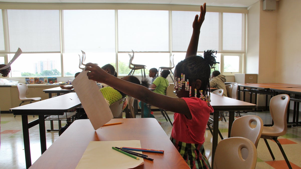  A student raises her hand during a summer reading program at West Philadelphia school. (Emma Lee/WHYY) Check out our series of podcasts and web “explainers