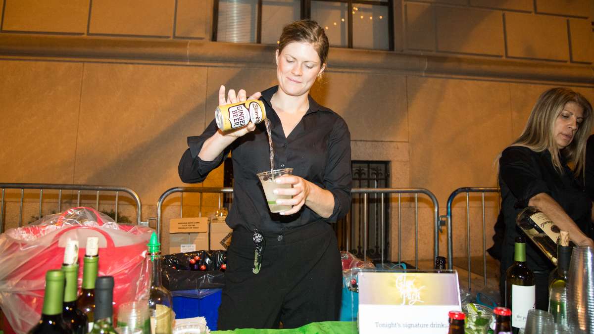 A bartender makes the night's signature drink, a Moscow Mule, with Tito's Homemade Vodka and Barritt's Ginger Beer.