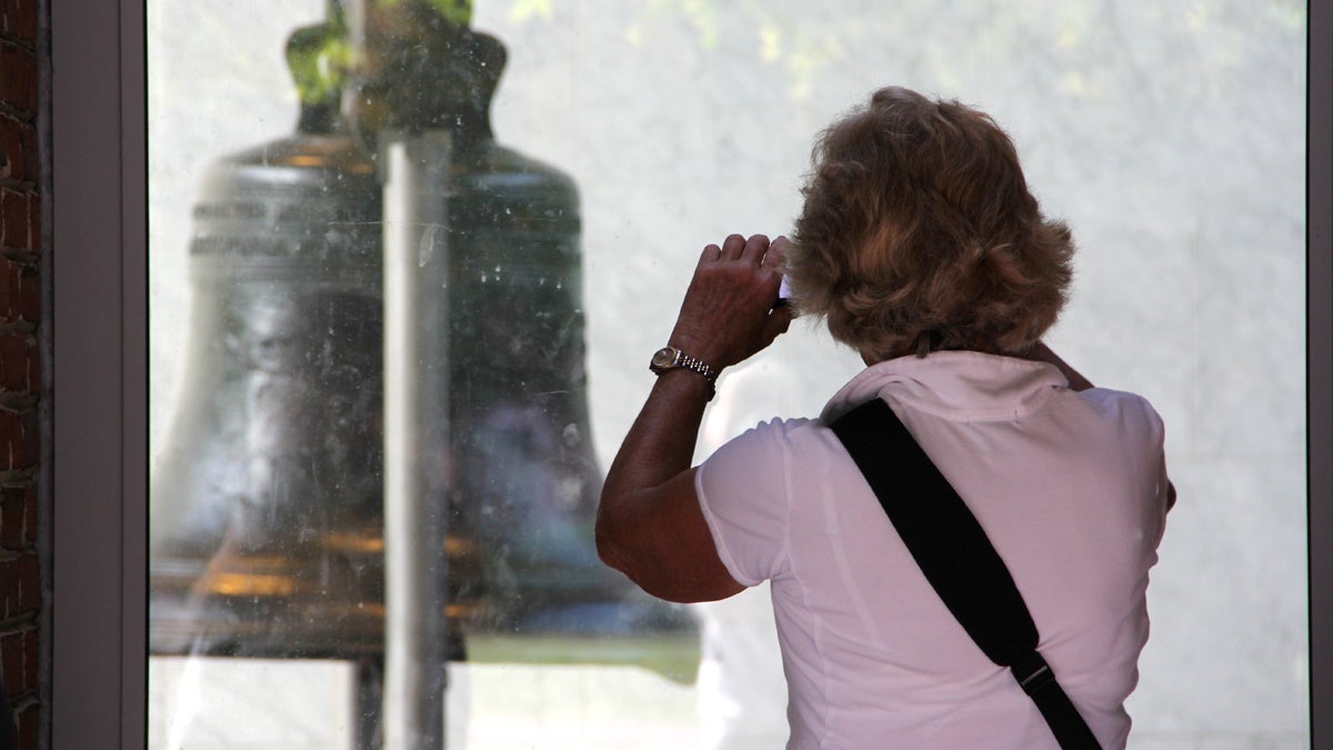  Susan Wilson, visiting Philadelphia from Minneapolis, takes a picture of the Liberty Bell through the glass of Independence Visitor Center, as close as she is likely to get during the government shutdown. (Emma Lee/for NewsWorks) 
