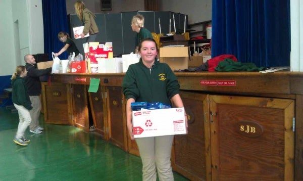 <p><p>Jessica Craighead carries a box to to the North Light Community Center van to be sorted through. (Yasmein James/for NewsWorks)</p></p>
